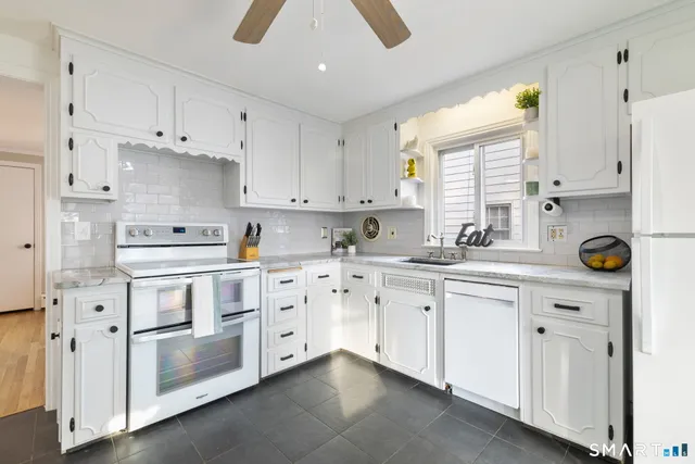 a kitchen with white cabinets and white appliances