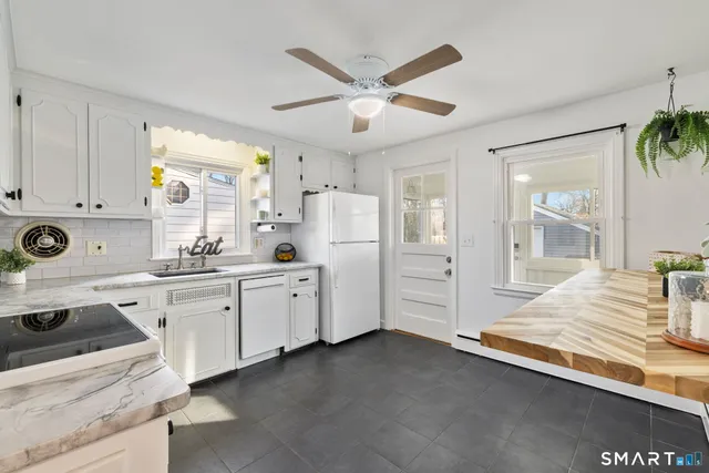 a kitchen with white cabinets and window