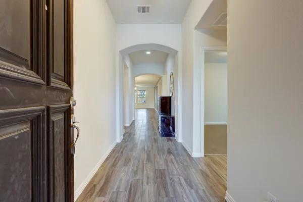 a view of a hallway with wooden floor and staircase