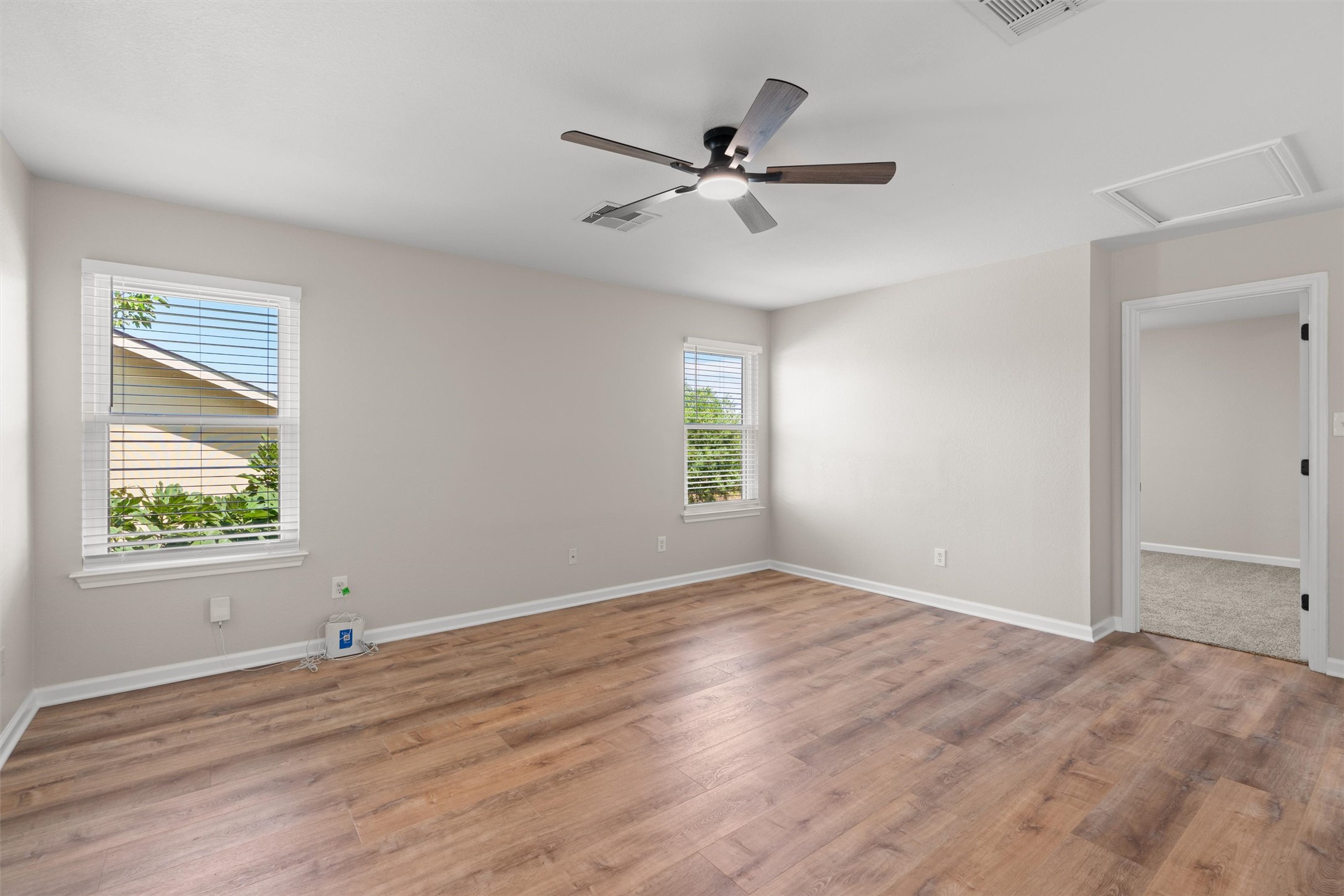 724 Lavaca Loop Elgin, TX 78621 - Photo 24 of 40 Smooth wood-look flooring and multiple windows define this versatile bedroom space.