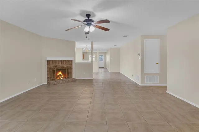 a view of empty room with fireplace and fan