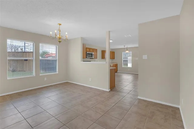 an empty room with chandelier and windows