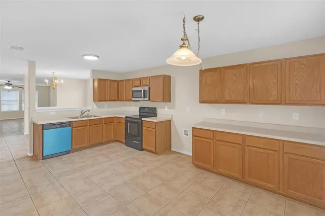 a kitchen with a sink counter top space cabinets and stainless steel appliances