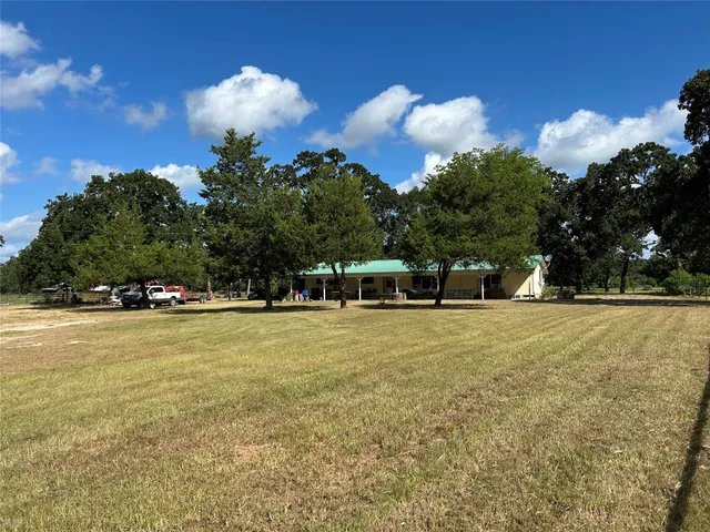 a front view of a house with a yard and trees