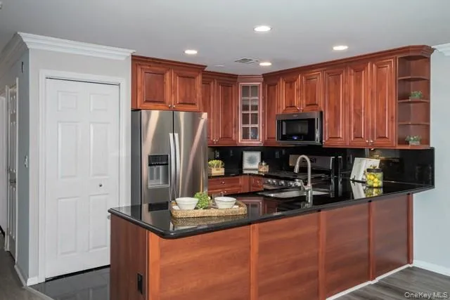 a kitchen with stainless steel appliances granite countertop a refrigerator and a stove top oven