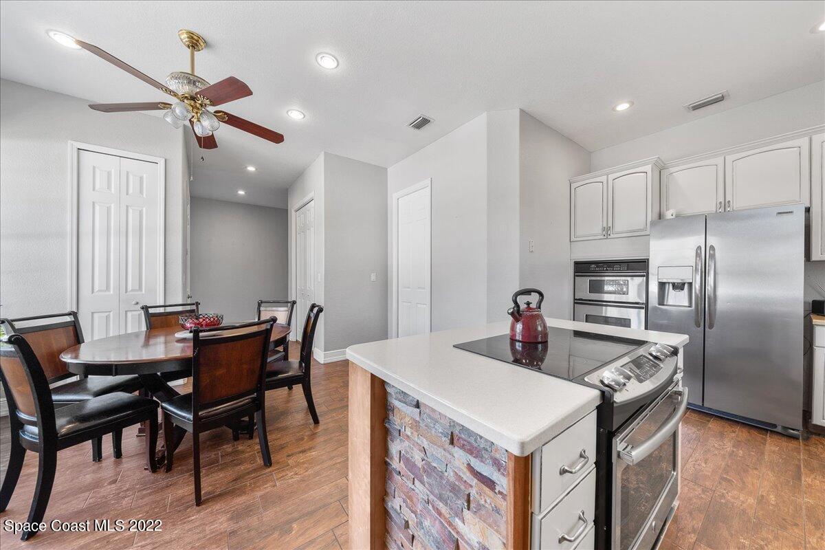 4450 Rayburn Road Cocoa, FL 32926 - Photo 14 of 45 a kitchen that has a kitchen island a stove a table and chairs in it