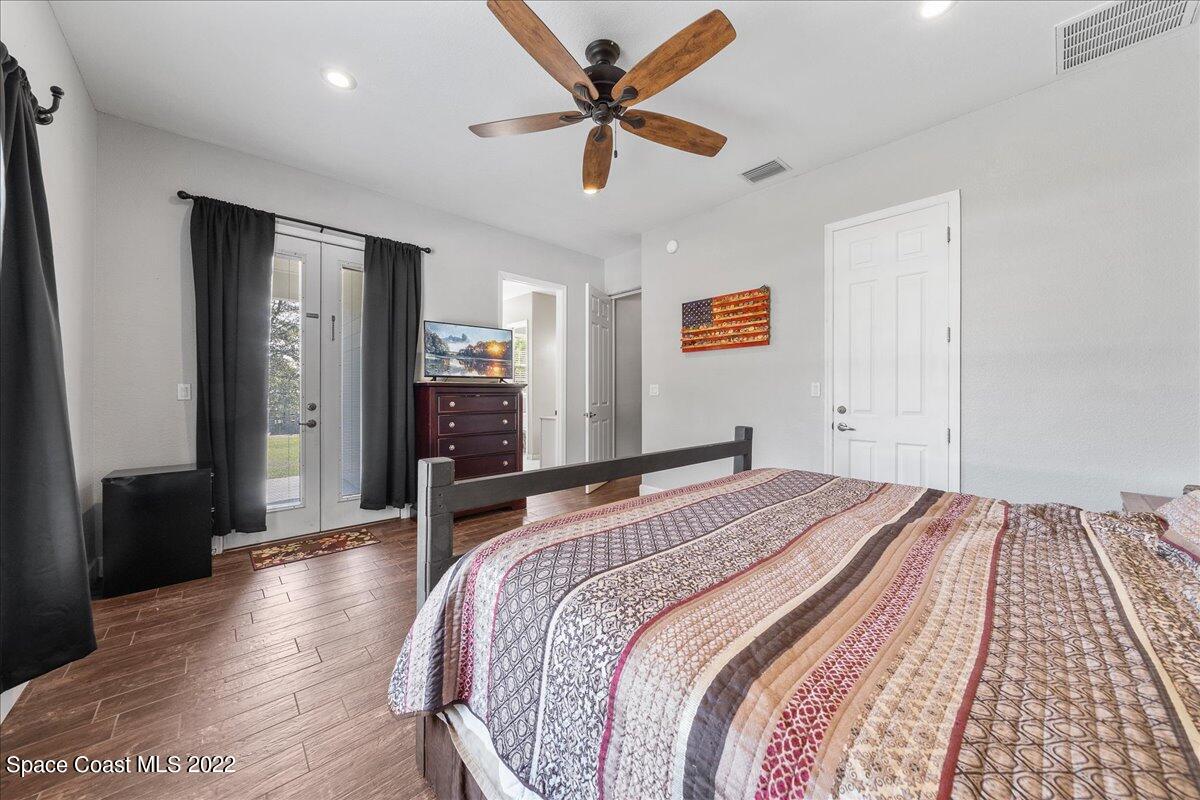 4450 Rayburn Road Cocoa, FL 32926 - Photo 16 of 45 a bedroom with a bed and a chandelier