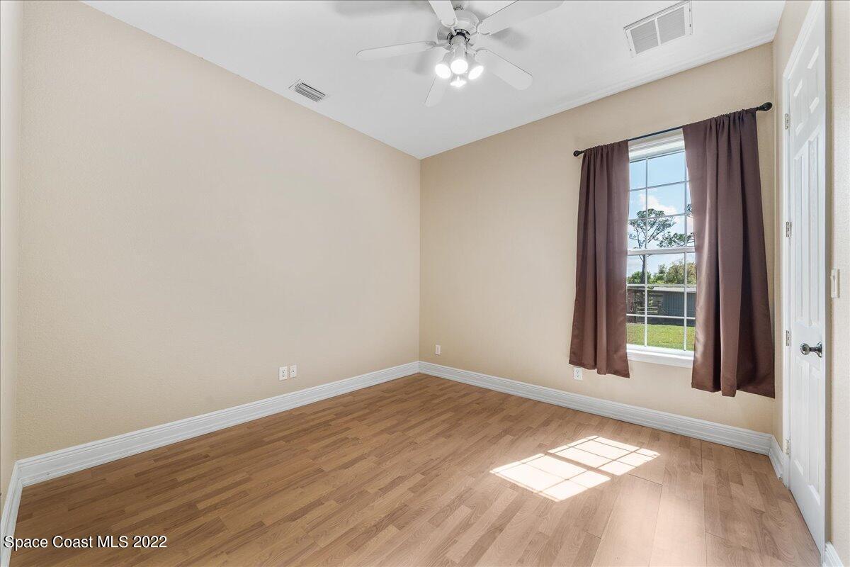 4450 Rayburn Road Cocoa, FL 32926 - Photo 20 of 45 a view of an empty room with wooden floor and a window