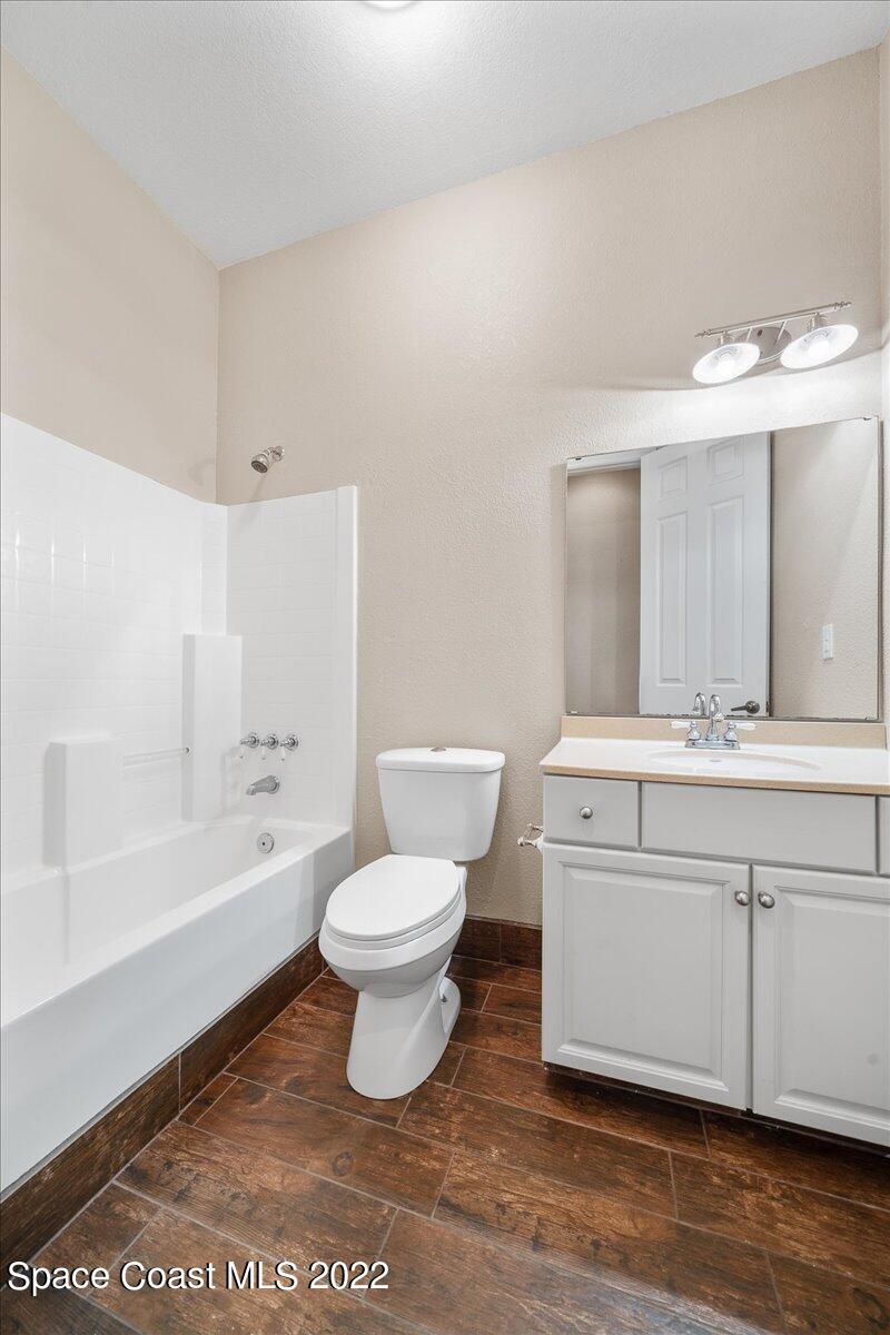 4450 Rayburn Road Cocoa, FL 32926 - Photo 21 of 45 a bathroom with a sink a toilet and a large mirror