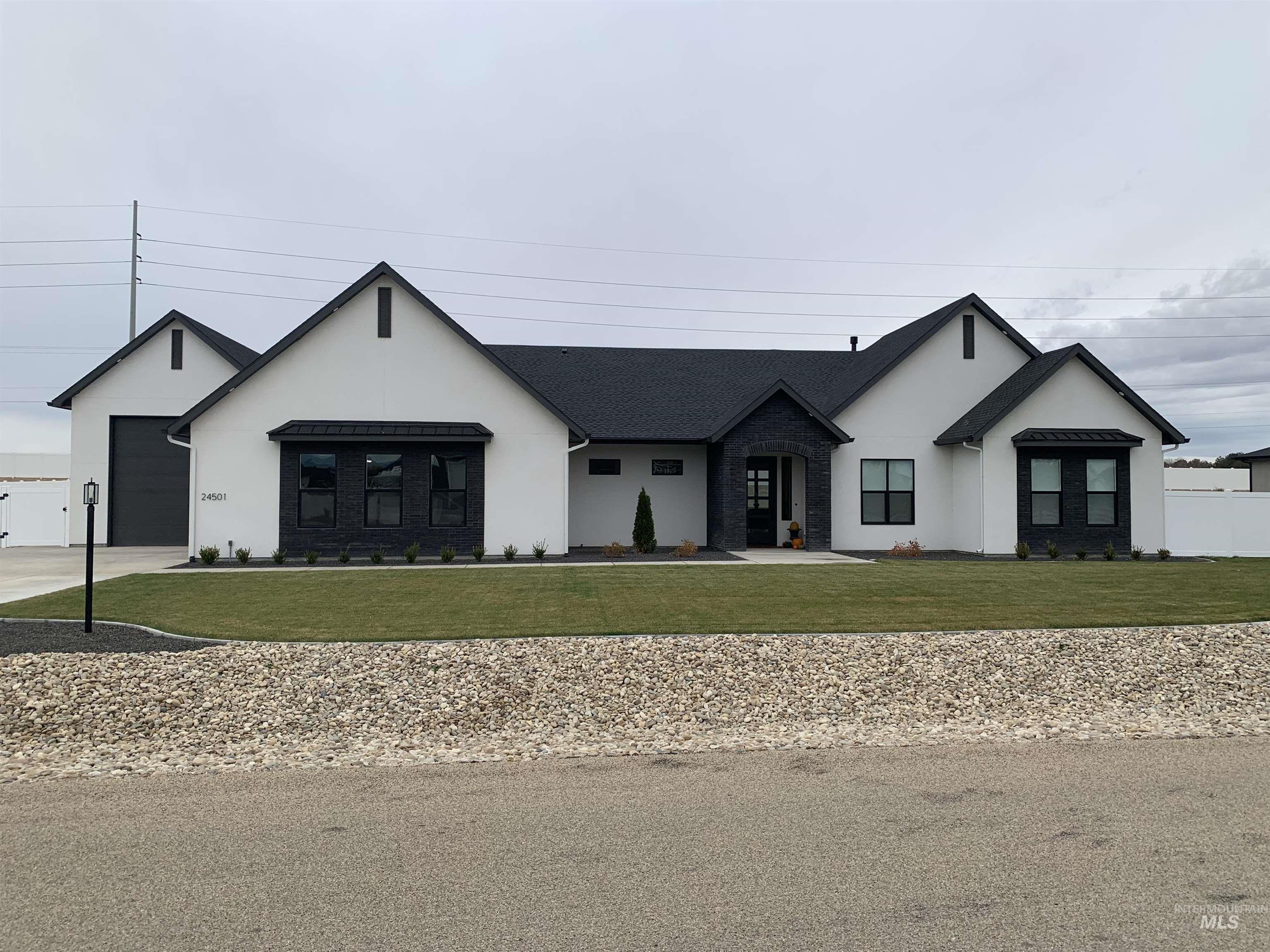 24501 Himark Way Caldwell, ID 83607 - Photo 1 of 27 Modern farmhouse style home with stucco siding, a front lawn, and concrete driveway