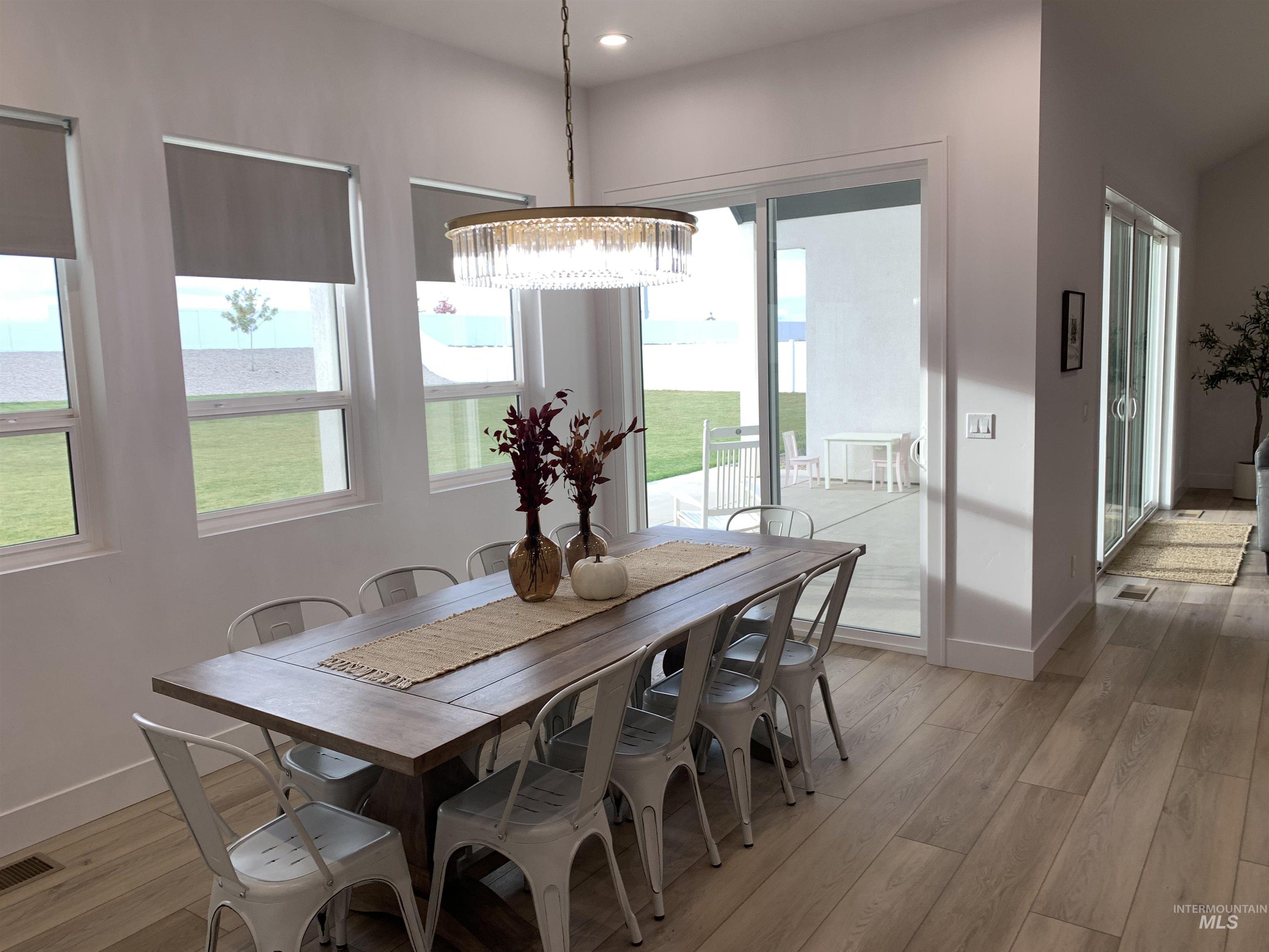 24501 Himark Way Caldwell, ID 83607 - Photo 18 of 27 Dining area featuring light wood-type flooring, healthy amount of natural light, and a chandelier