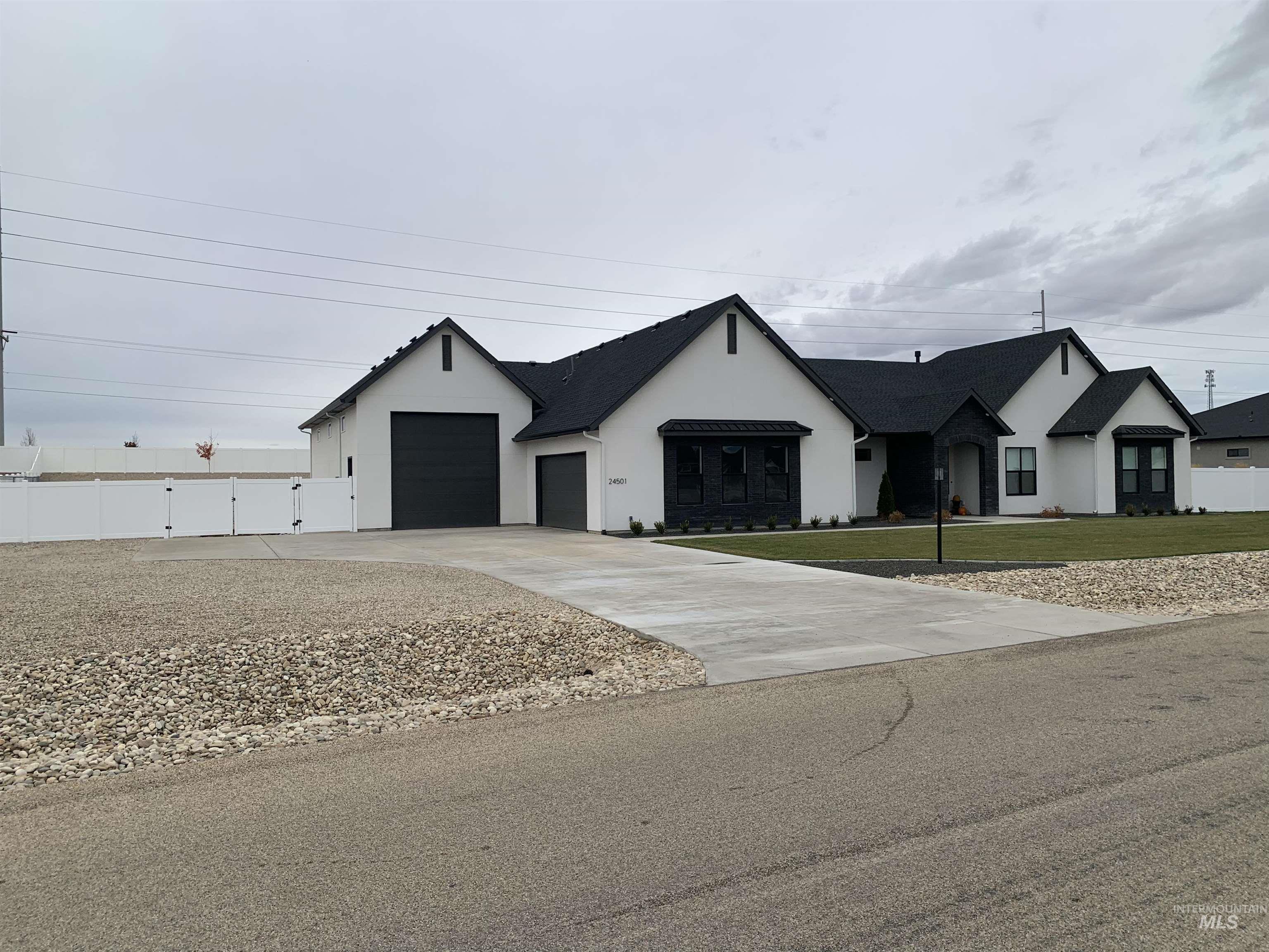 24501 Himark Way Caldwell, ID 83607 - Photo 3 of 27 View of front facade with concrete driveway, stucco siding, and a gate