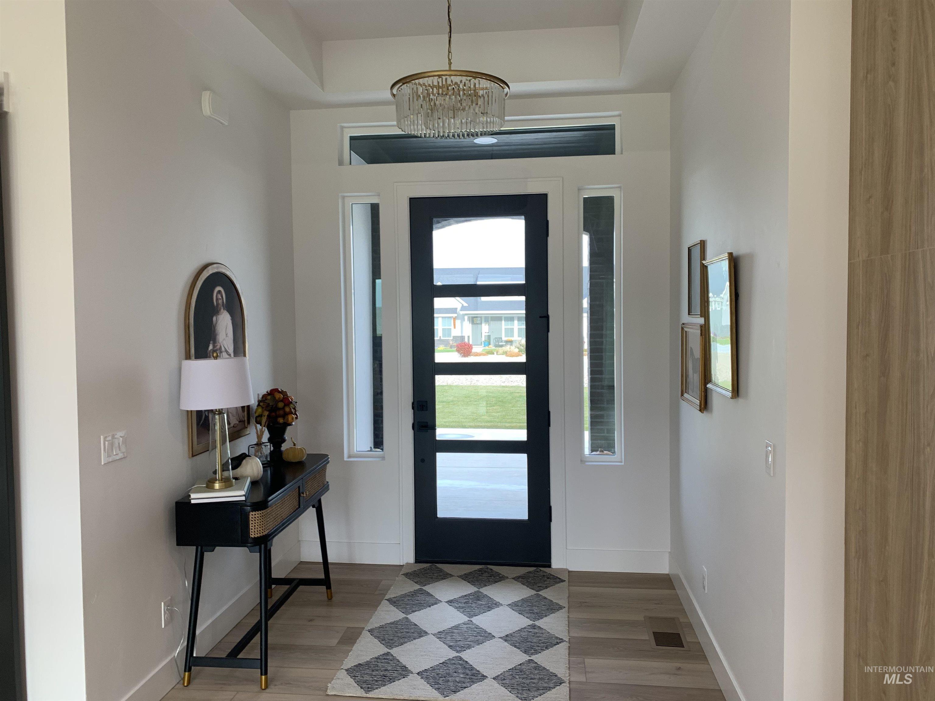 24501 Himark Way Caldwell, ID 83607 - Photo 7 of 27 Foyer featuring light wood-style floors and a chandelier