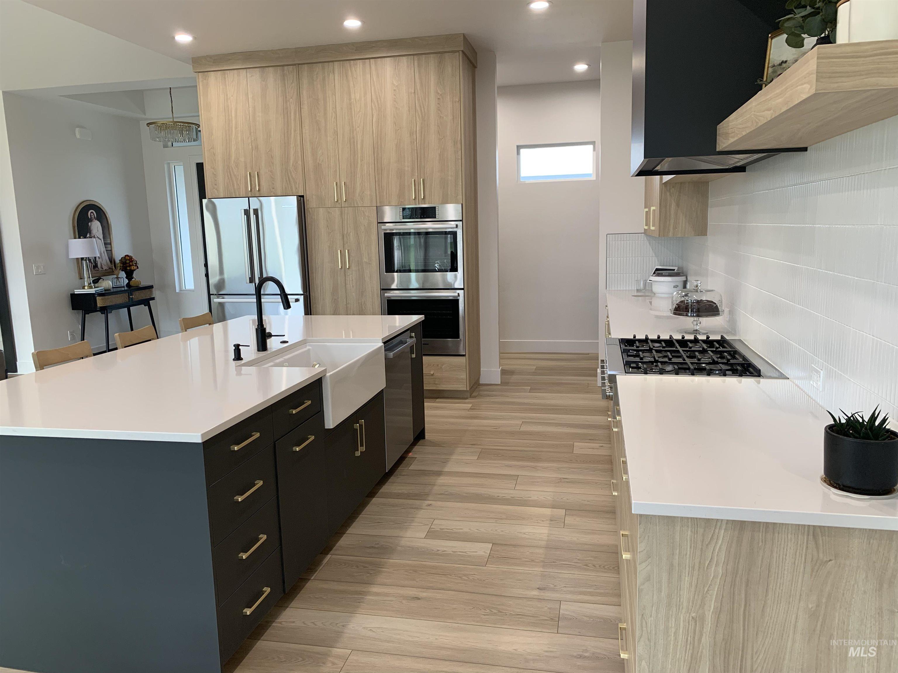 24501 Himark Way Caldwell, ID 83607 - Photo 9 of 27 Kitchen featuring modern cabinets, dark cabinetry, light stone countertops, appliances with stainless steel finishes, and recessed lighting