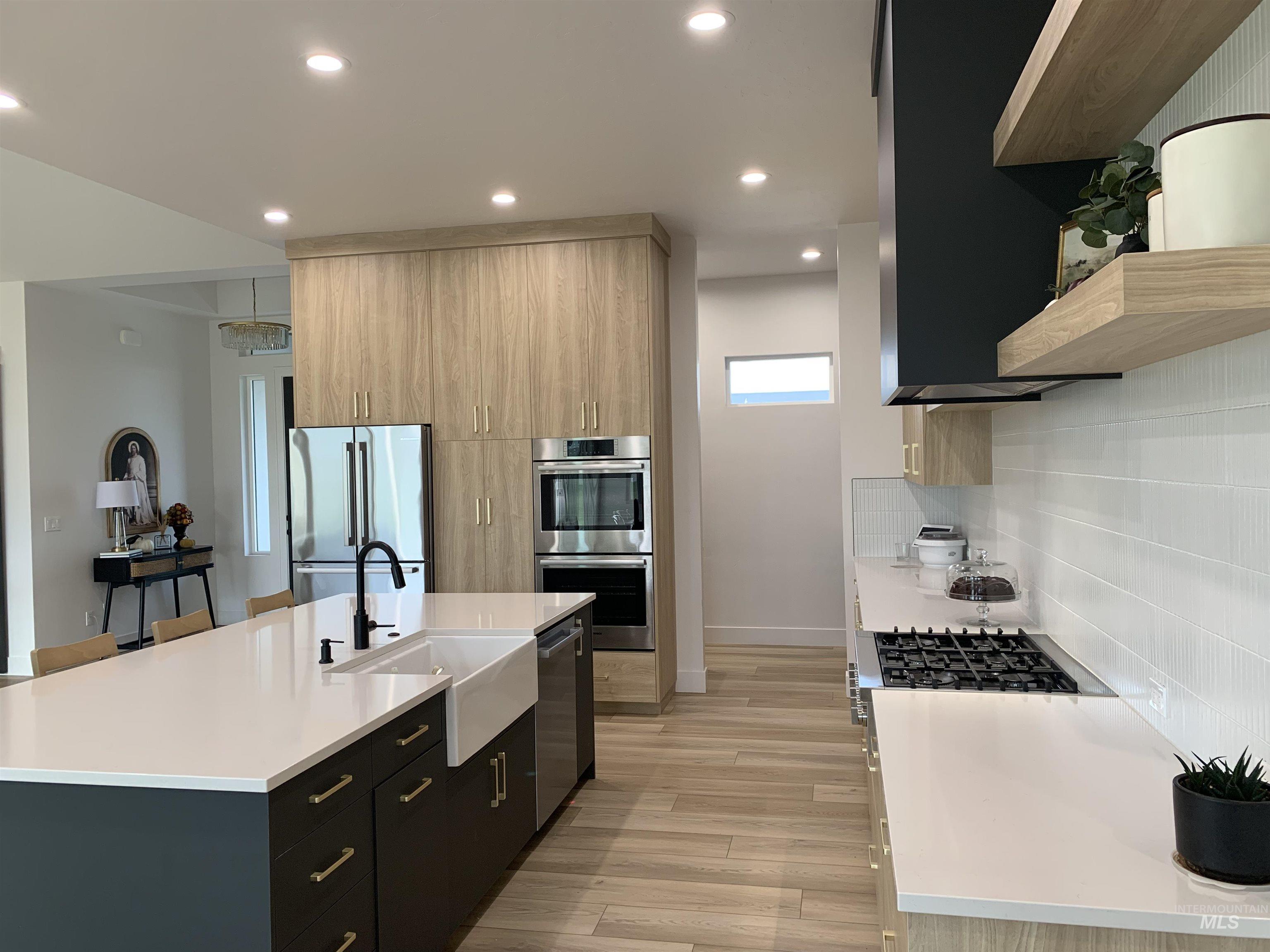 24501 Himark Way Caldwell, ID 83607 - Photo 10 of 27 Kitchen with dark cabinetry, open shelves, modern cabinets, light stone countertops, and stainless steel appliances