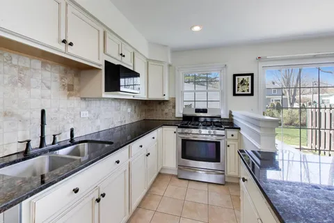 a kitchen with stainless steel appliances granite countertop a stove a sink and a microwave