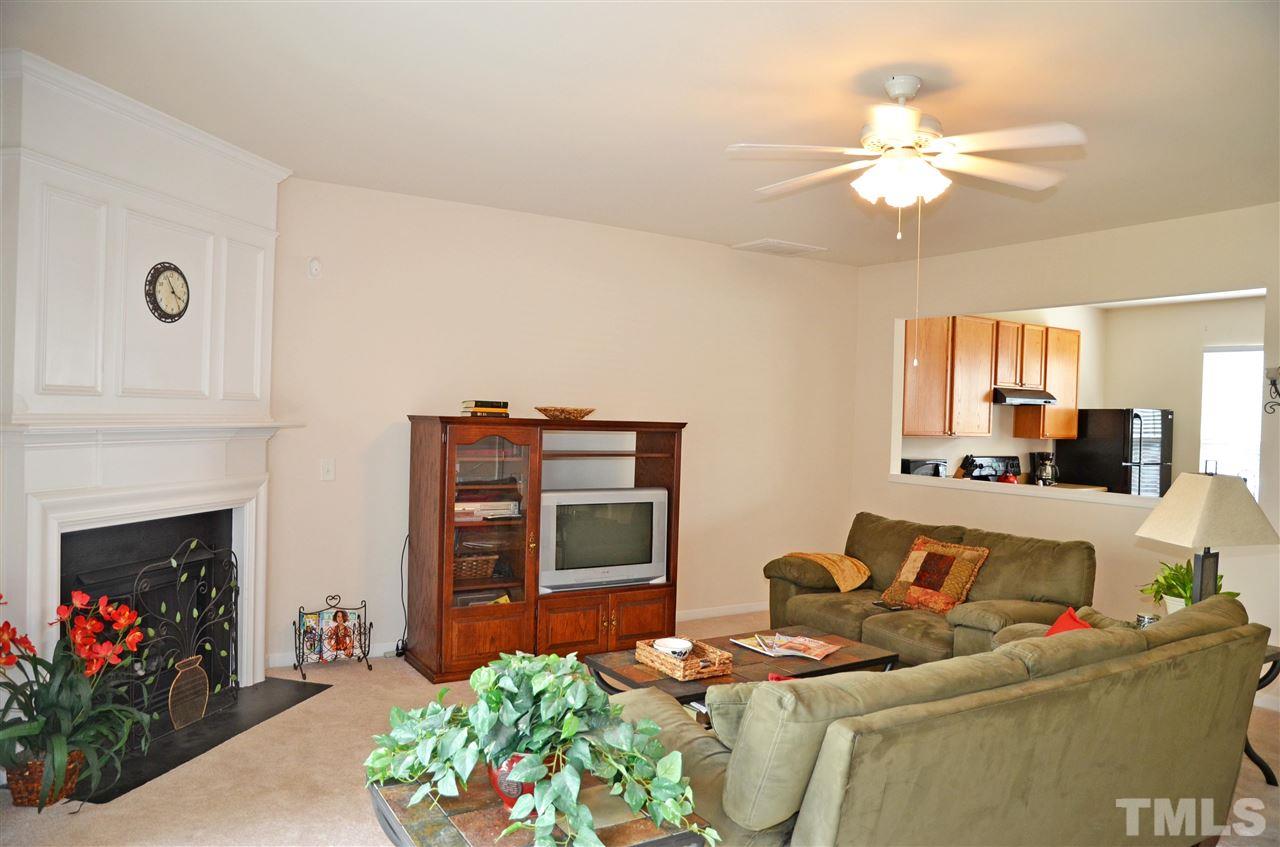 8520 Silhouette Place Raleigh, NC 27613 - Photo 5 of 17 a living room with furniture a fireplace and a chandelier