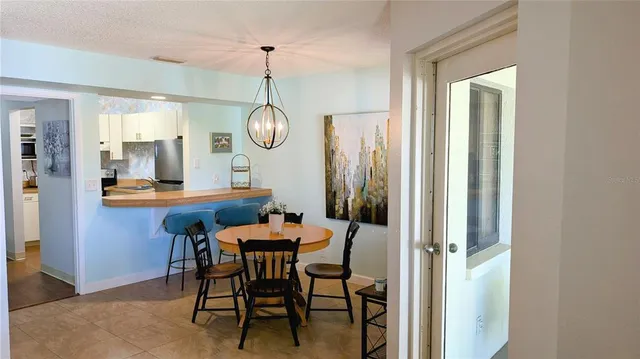 a dining room with furniture a chandelier and wooden floor