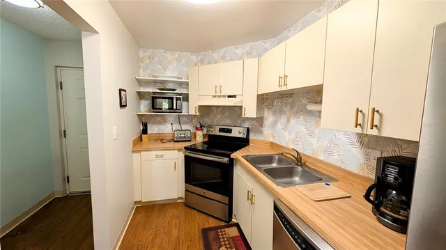 a kitchen that has a sink cabinets counter space and stainless steel appliances