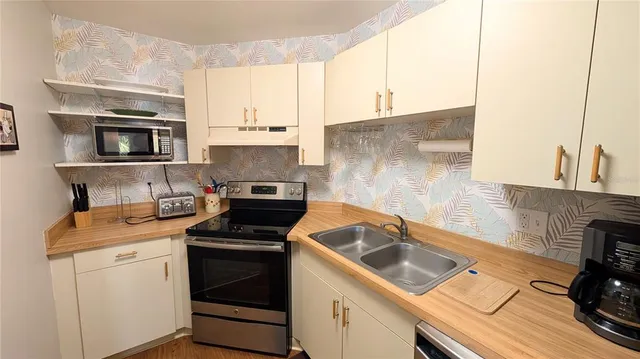a kitchen with a sink stove top oven and cabinets