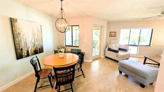 a dining room with furniture a chandelier and wooden floor