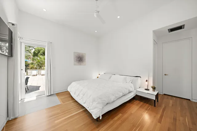 a bed sitting in a spacious bedroom next to a window