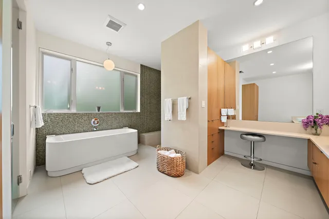 a bathroom with a tub sink and mirror