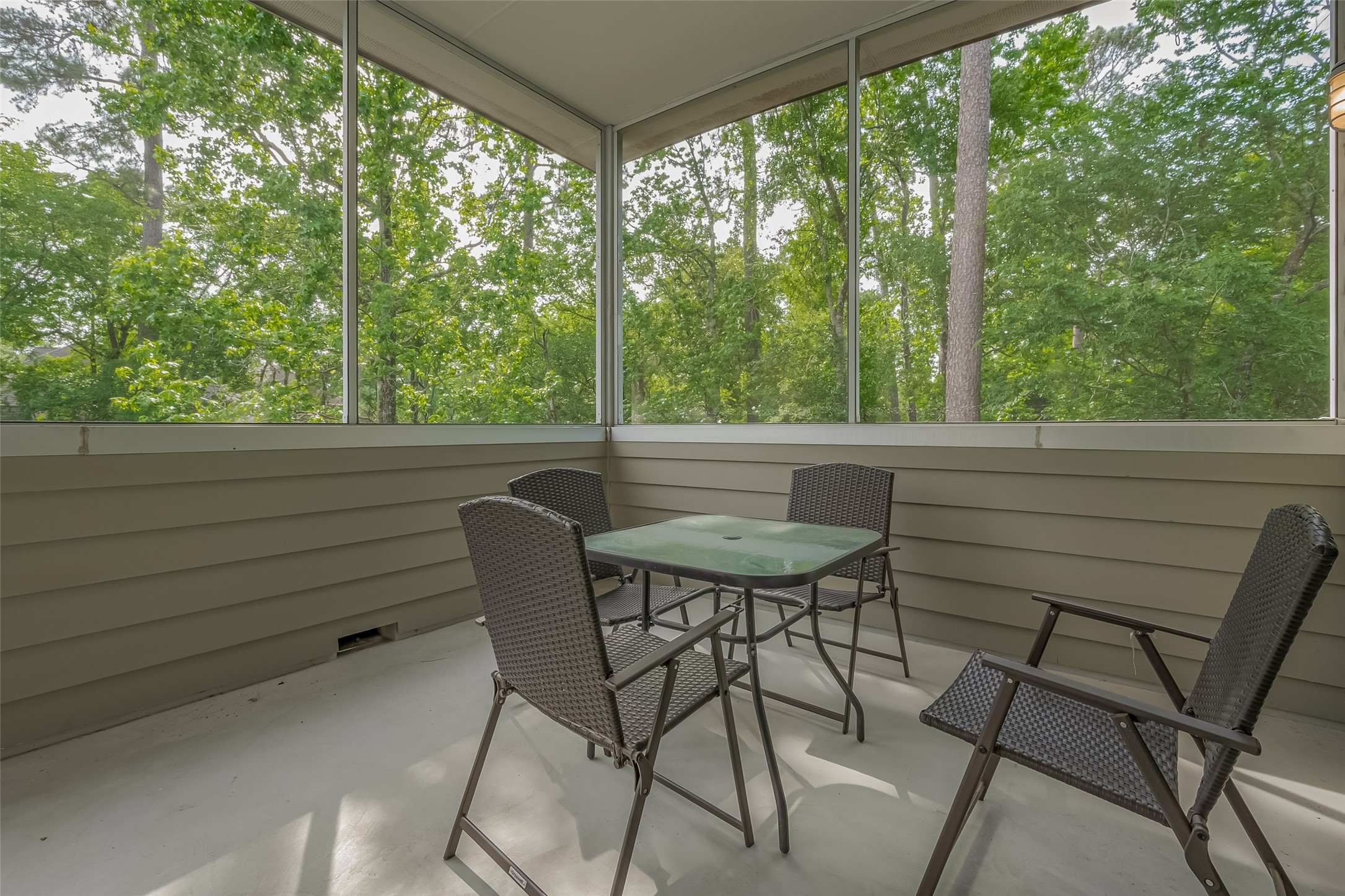 118 Angel Leaf Road Spring, TX 77380 - Photo 22 of 50 Screened-in patio surrounded by lush trees, perfect for peaceful outdoor dining or morning coffee.