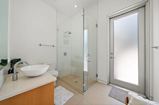 a bathroom with a granite countertop sink mirror and shower