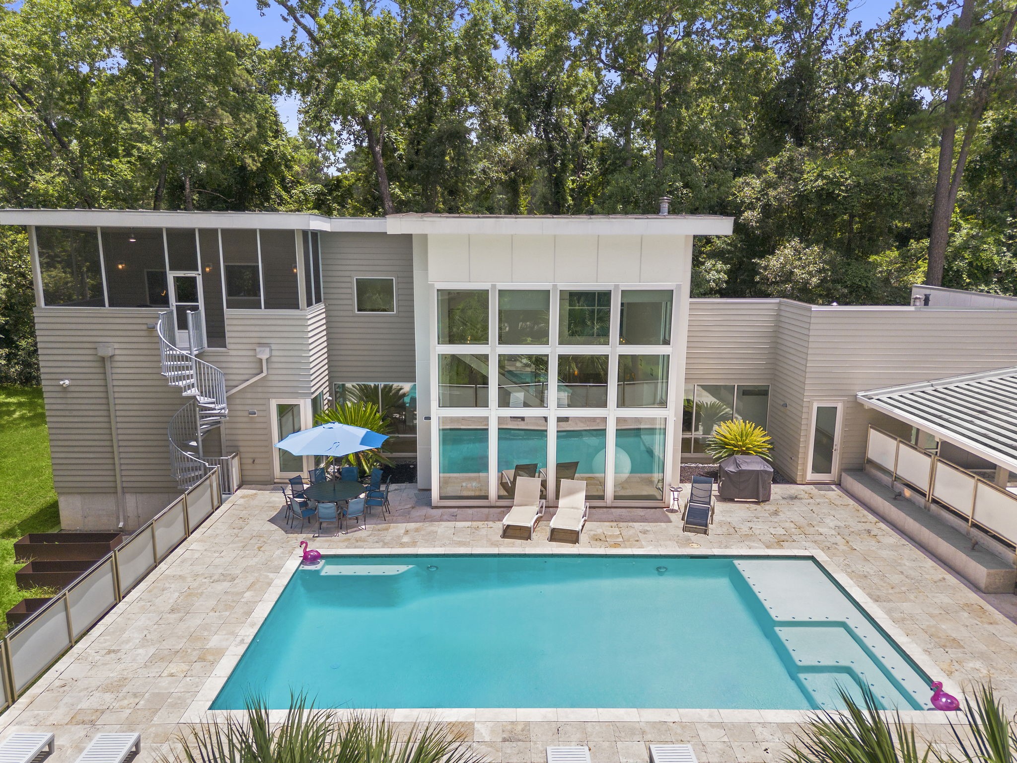 118 Angel Leaf Road Spring, TX 77380 - Photo 39 of 50 Poolside view of the home's glass façade and lush landscaping.