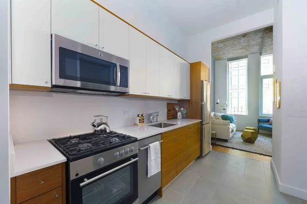 a kitchen with stainless steel appliances a stove microwave and cabinets