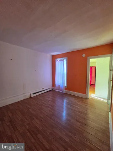 a view of an empty room with wooden floor