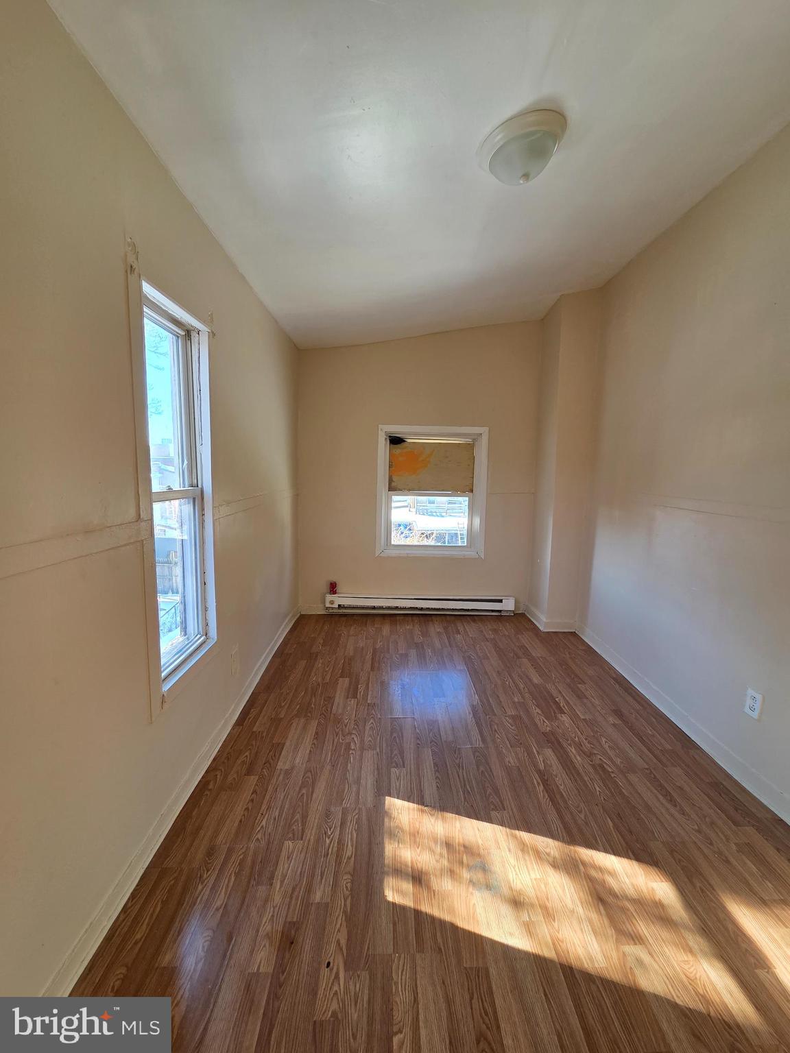 42 Maple Street Reading, PA 19602 - Photo 12 of 18 an empty room with wooden floor and windows