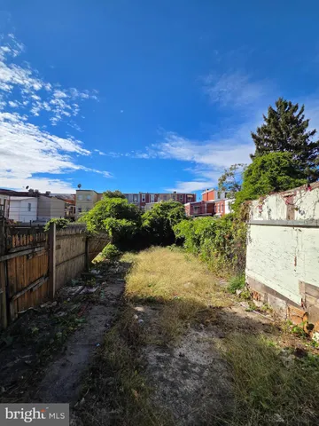 a view of a yard with wooden fence