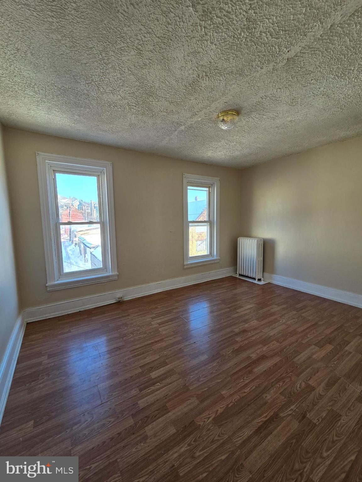 42 Maple Street Reading, PA 19602 - Photo 9 of 18 an empty room with wooden floor and windows