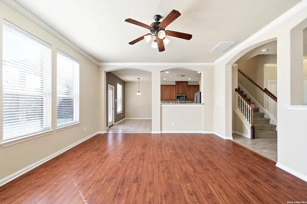 a view of an empty room with window and wooden floor
