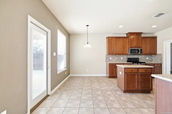 a large kitchen with stainless steel appliances granite countertop a stove a sink and a refrigerator