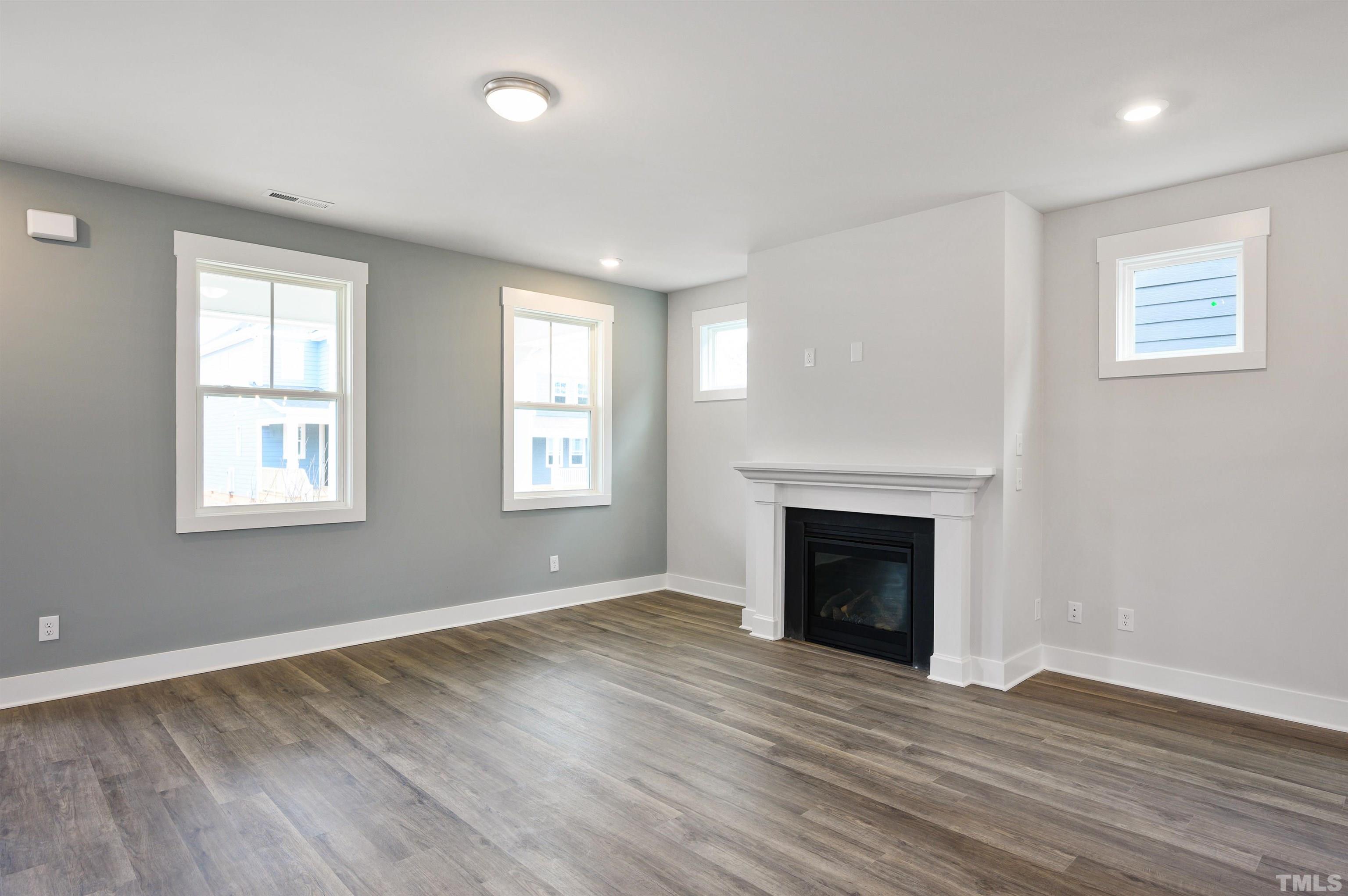 517 Friendship Chapel Road, Unit HVA0055 Wake Forest, NC 27587 - Photo 33 of 58 an empty room with wooden floor fireplace and windows