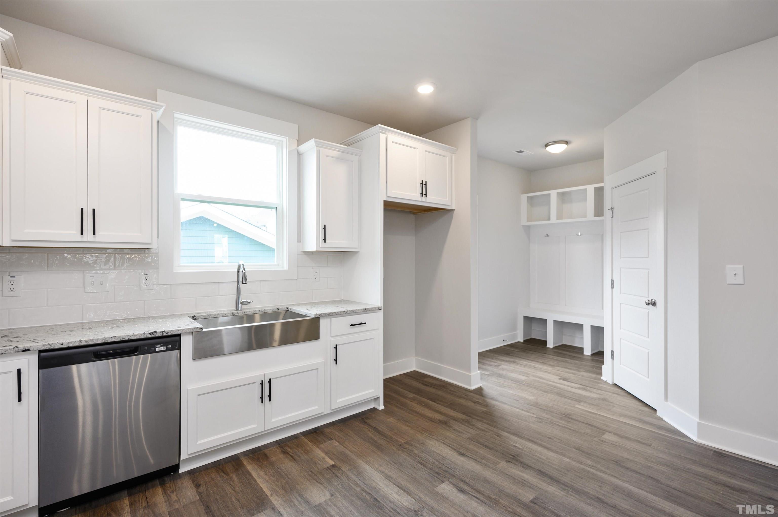 517 Friendship Chapel Road, Unit HVA0055 Wake Forest, NC 27587 - Photo 40 of 58 a kitchen with white cabinets and wooden floors