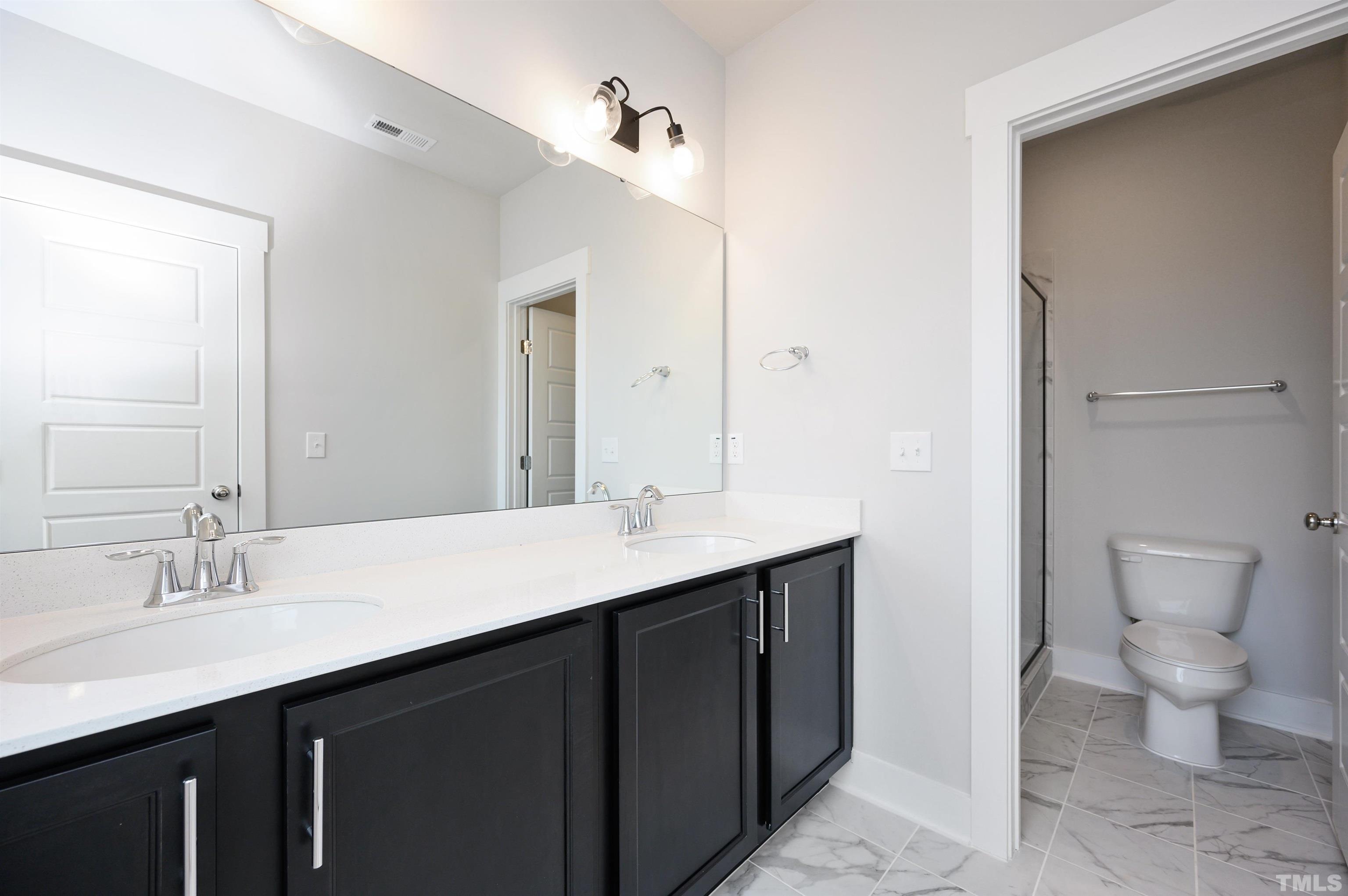 517 Friendship Chapel Road, Unit HVA0055 Wake Forest, NC 27587 - Photo 45 of 58 a bathroom with a double vanity sink toilet and a mirror