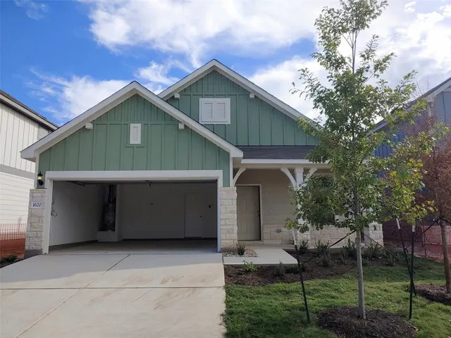 a front view of a house with plants