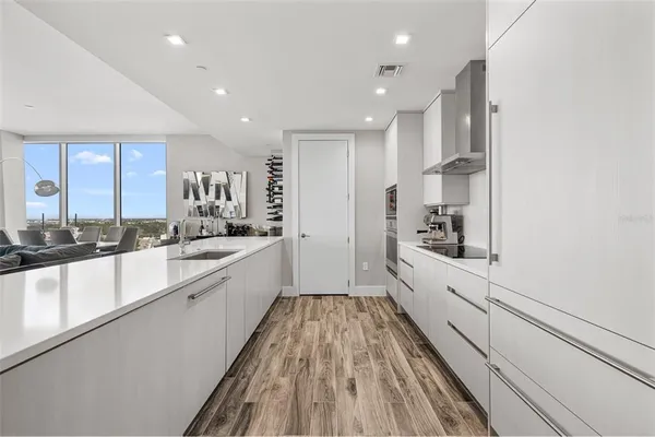 a large white kitchen with lots of counter space a sink and appliances