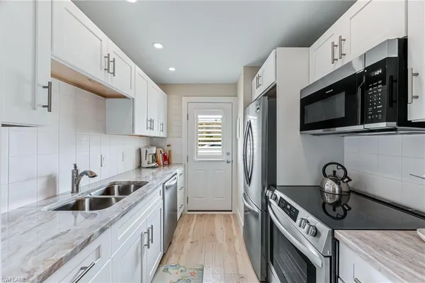 a kitchen with stainless steel appliances a sink a stove and cabinets
