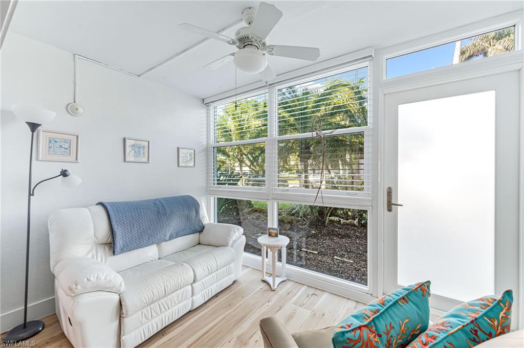 1021 3rd Street South, Unit 110 Naples, FL 34102 - Photo 23 of 30 a living room with furniture and a floor to ceiling window