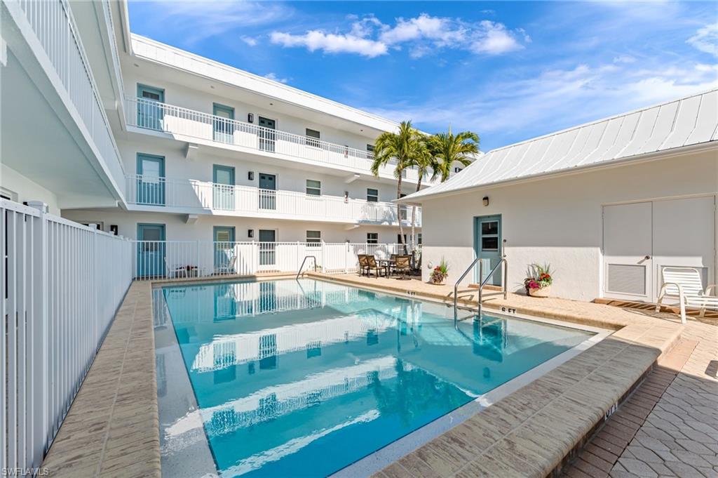 1021 3rd Street South, Unit 110 Naples, FL 34102 - Photo 4 of 30 a view of a swimming pool with a lounge chairs