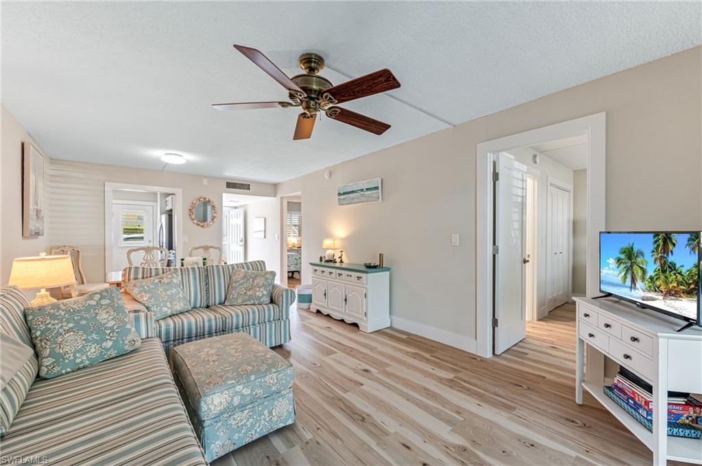 1021 3rd Street South, Unit 110 Naples, FL 34102 - Photo 10 of 30 a living room with furniture and a wooden floor