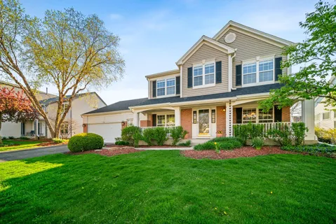 a front view of a house with a yard and trees