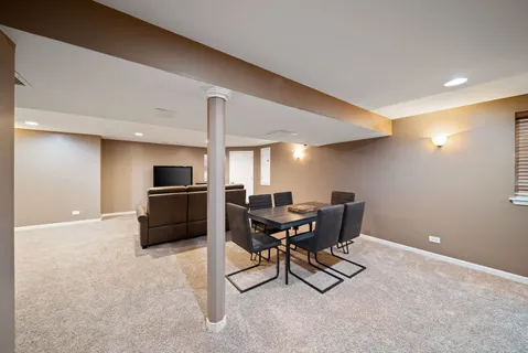 a kitchen with a refrigerator and chairs