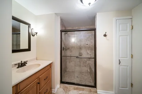 a bathroom with a shower sink and mirror