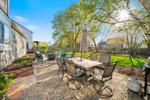a view of a patio with a table and chairs under an umbrella